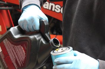 A closeup of a few drops of fresh oil being poured on an oil filter.