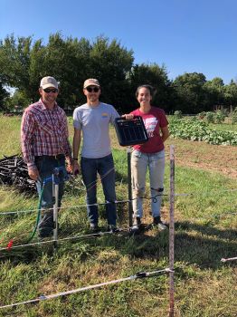 Kenny Simon, Luke Freeman, and Jenni Vaughan set up an electric deer fence.