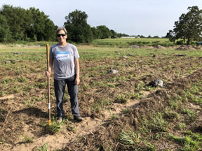 Incubator farm project participant stands in field.